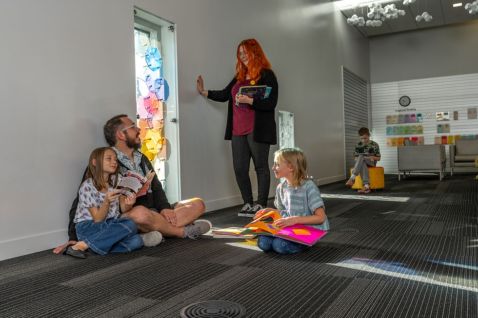 Parent and children talking with library staff in children's area in the Weber County Library