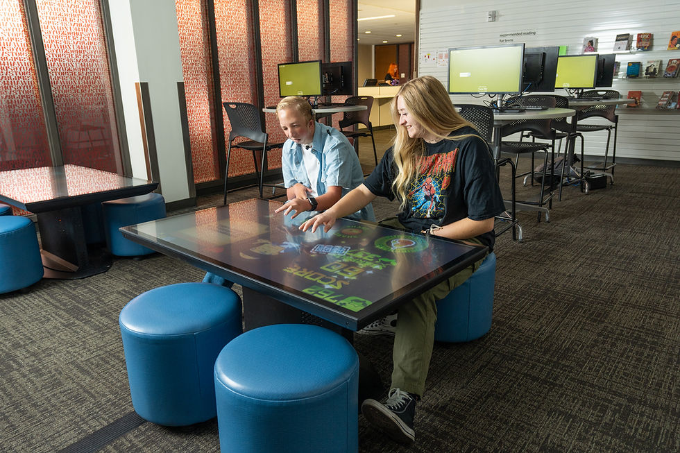 two people playing a game on a tablet table at the Weber County Library
