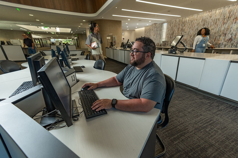 Man reading newspapers on computer at Weber County Library