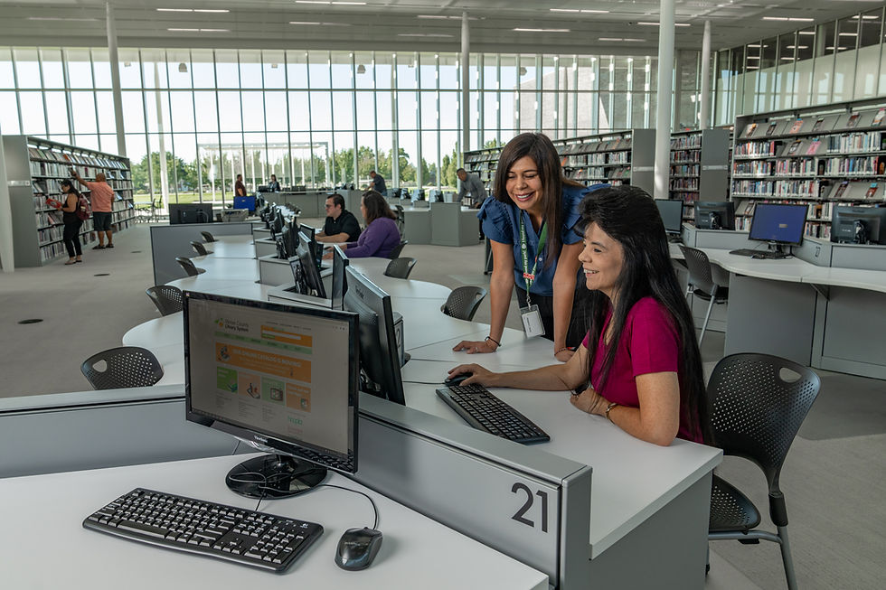 Librarian helping person sitting at computer at Weber County Library