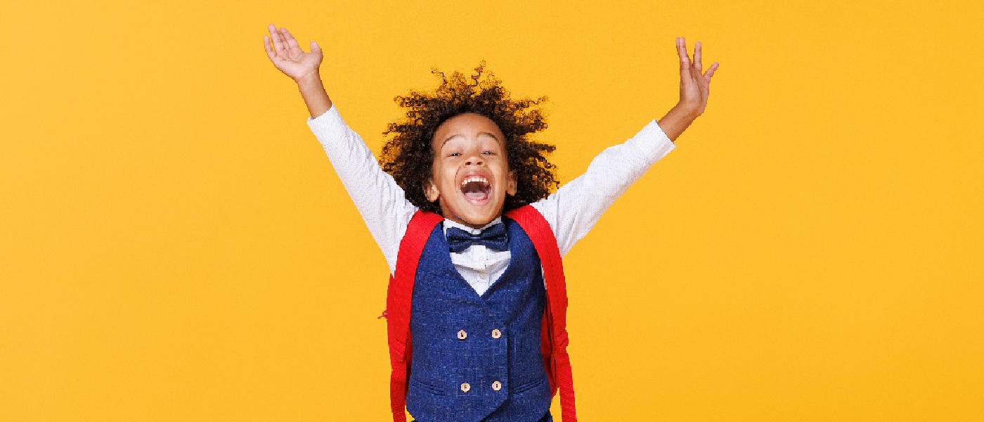boy with a backpack on jumping in the air excitedly
